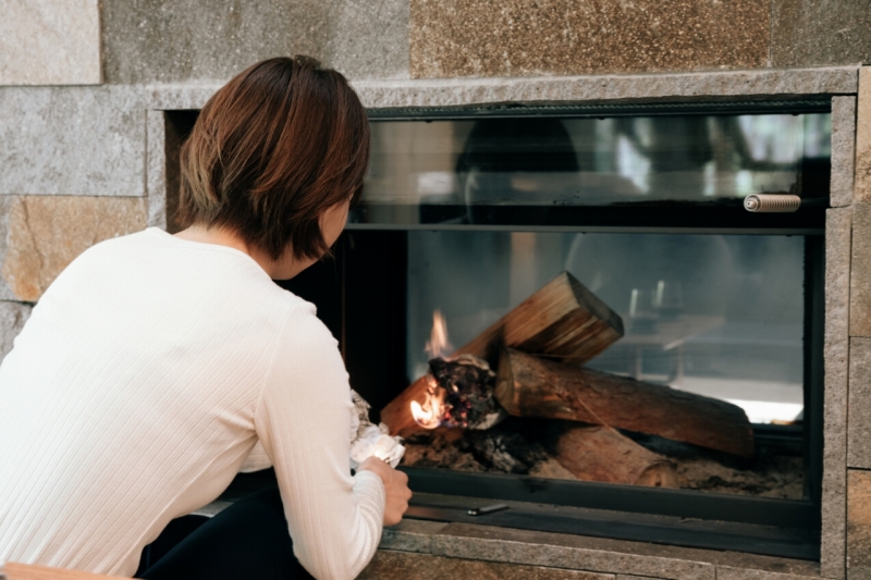 暖炉に火をつける女性