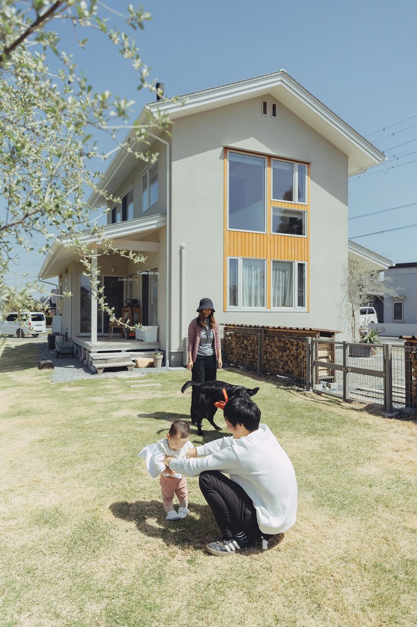 庭で犬と子と遊ぶ夫婦