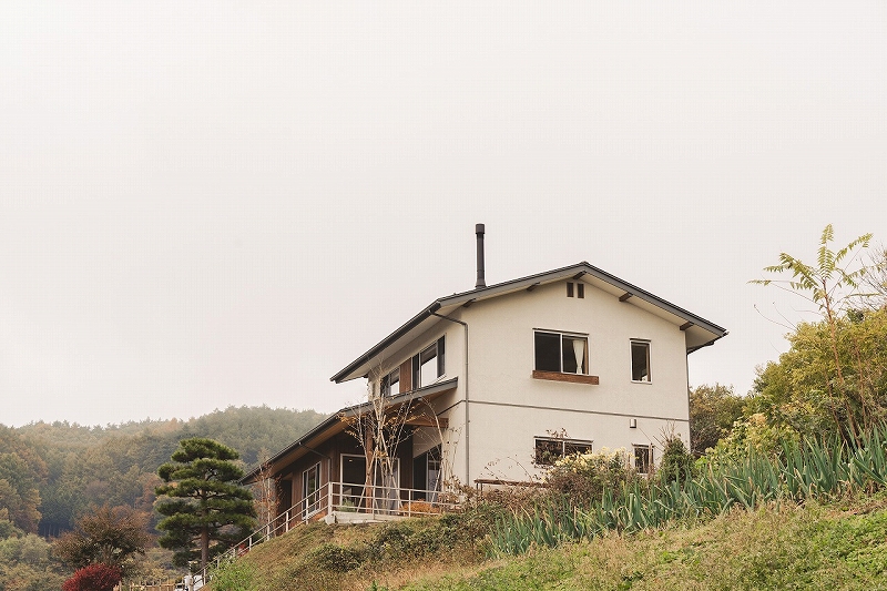 山裾に佇む切妻屋根の家