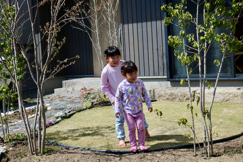 芝生の庭で遊ぶ女の子2人