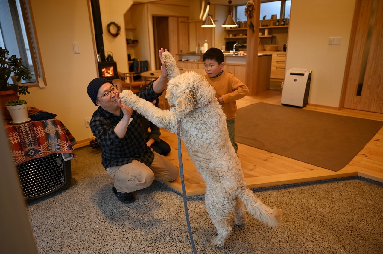 土間サロンで遊ぶ家族と犬