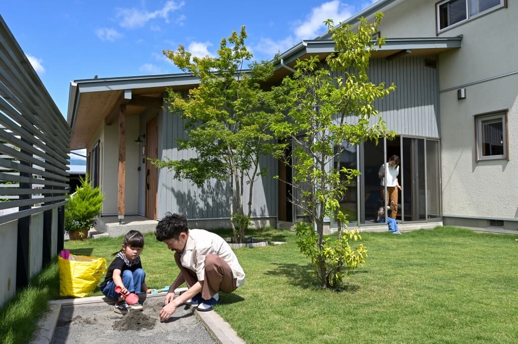 天然芝の庭で遊ぶ親子